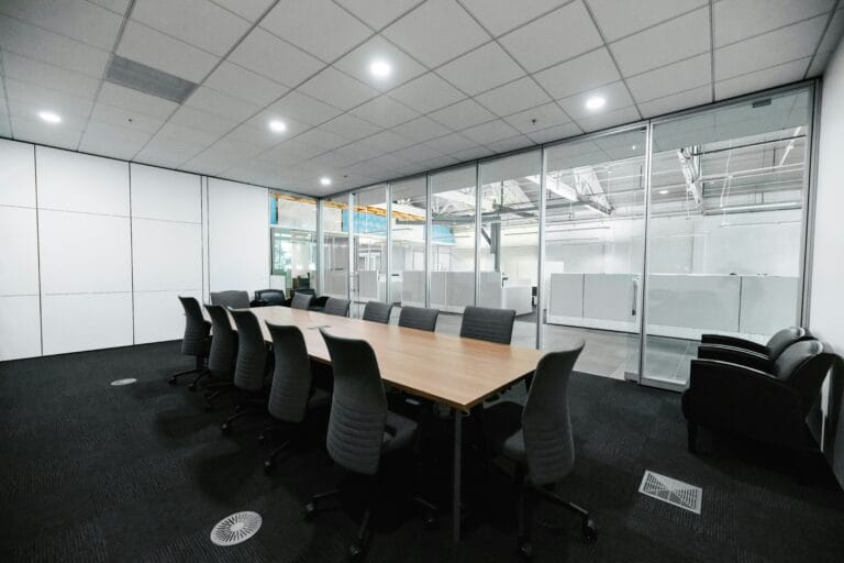 Modern glass acoustic partition separating meeting rooms while maintaining an open office feel